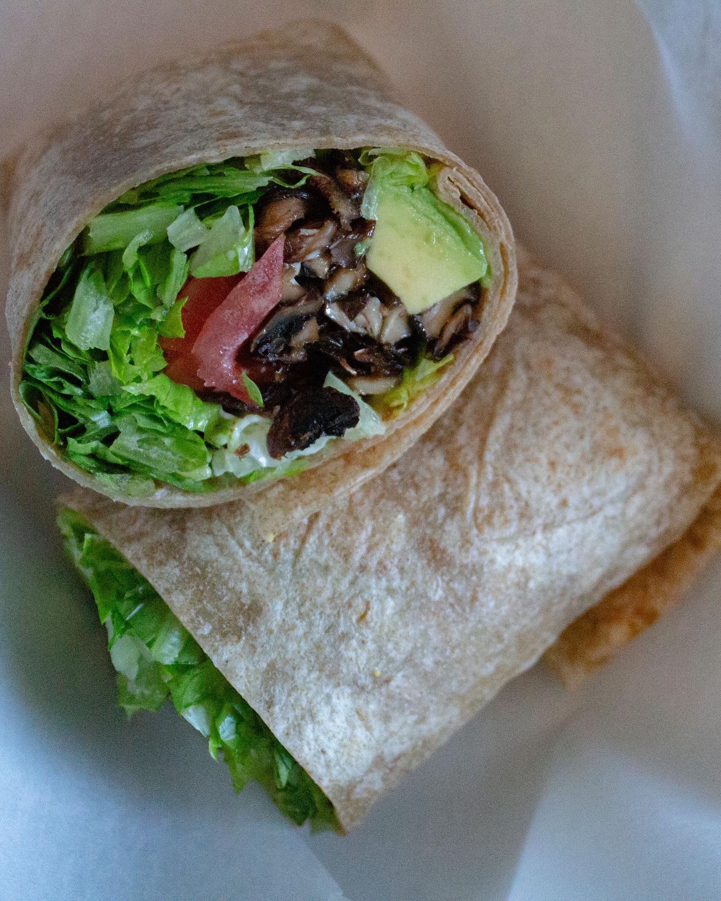 Wrap cut in half showing lettuce, avocado and crispy shiitake mushrooms