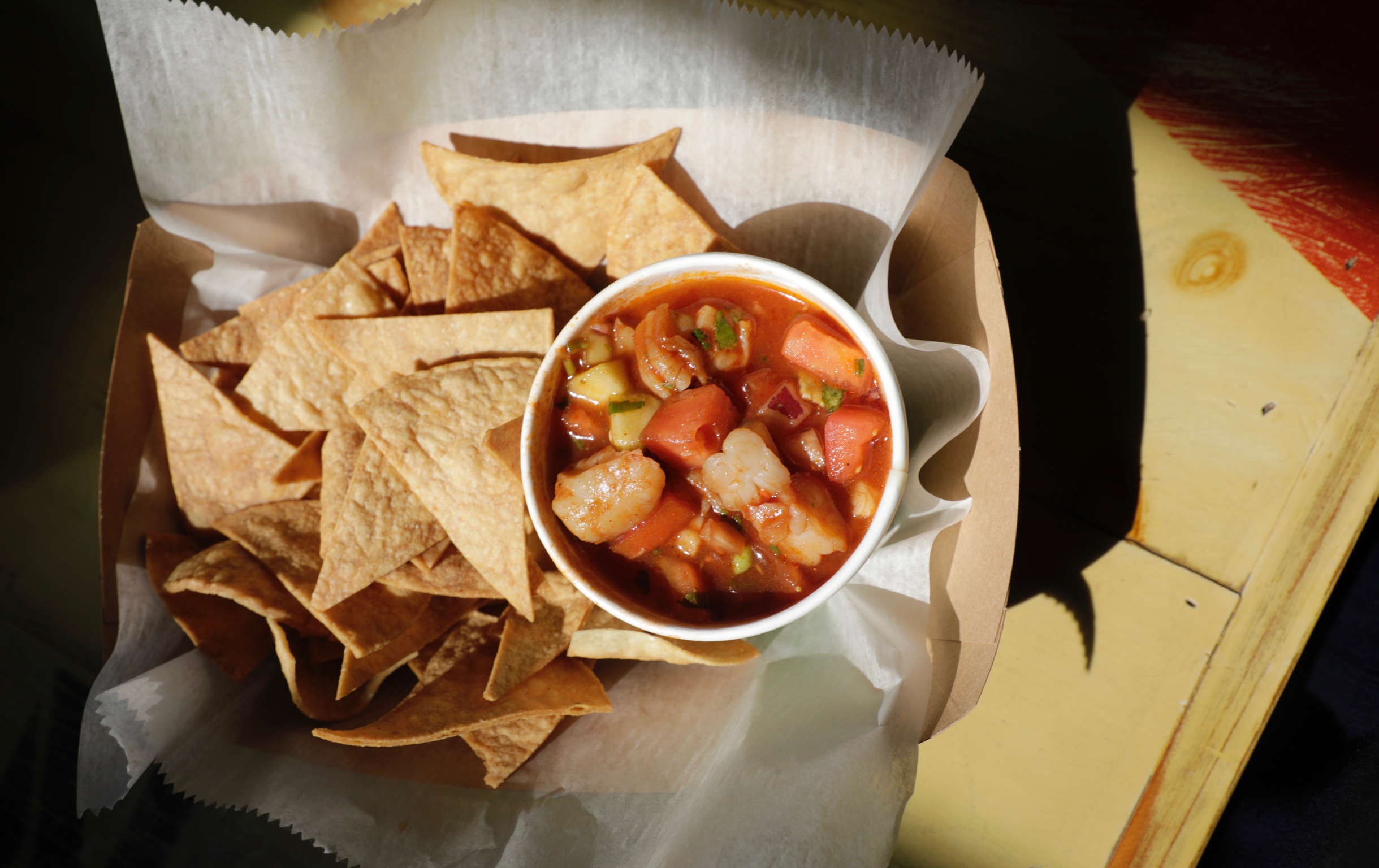 Cup of fresh tomato salsa surrounded by tortilla chips