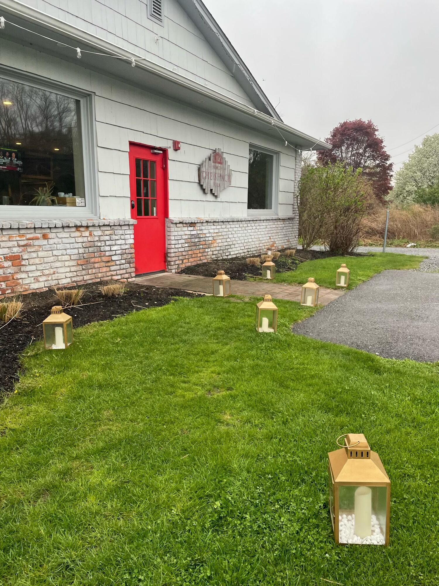 Gold lanterns lining the lawn up to the Shack's red front door